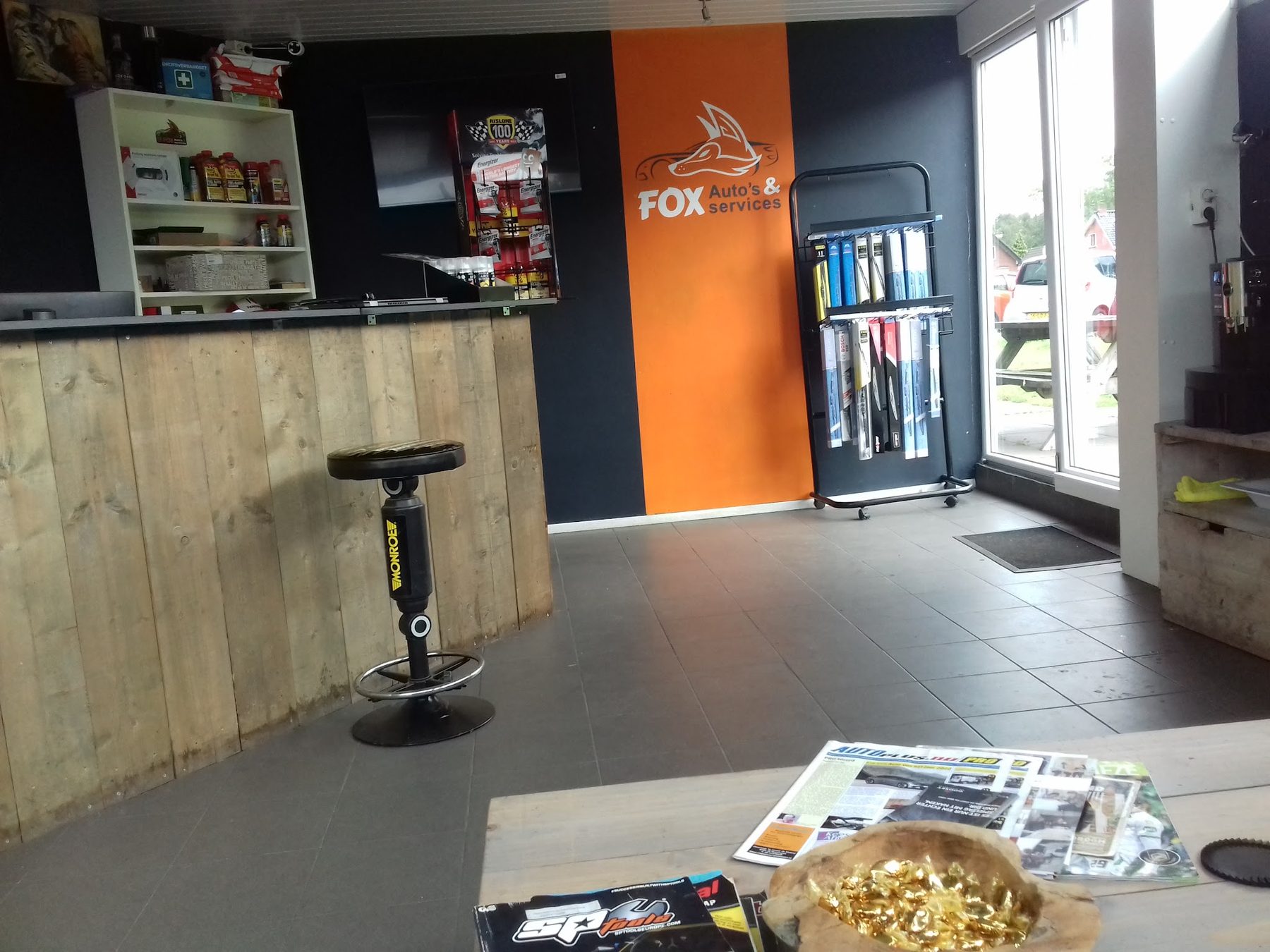 De ontvangstruimte met houten balie en de oranje FOX wand